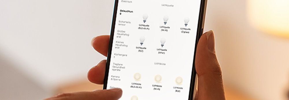 Person steuert Smart Home Beleuchtung über Smartphone